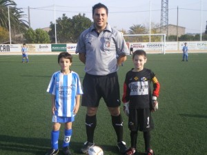 El colegiado con los capitanes del partido