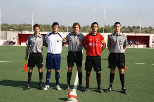 El trio arbitral con los capitanes del partido