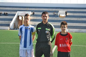 El colegiado con los capitanes del partido