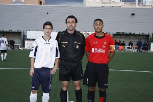 El colegiado con los capitanes del partido