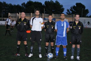 El trio arbitral con los capitanes del partido