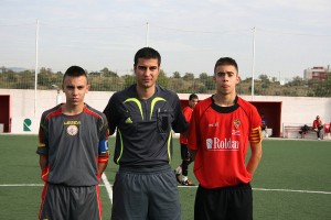 El colegiado con los capitanes del partido