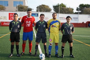 El trío arbitral con los capitanes del partido