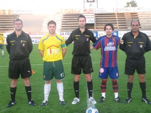 El trío arbitral con los capitanes del partido