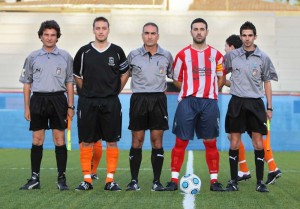 El trio arbitral con los capitanes del partido