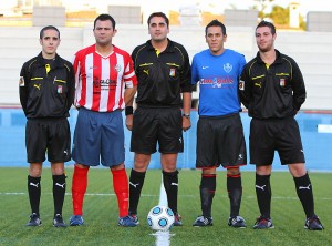 El trío arbitral con los capitanes del partido