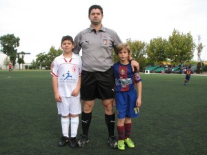 El colegiado con los capitanes del partido