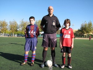 El colegiado con los capitanes del partido