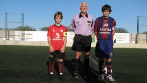 El colegiado con los capitanes del partido