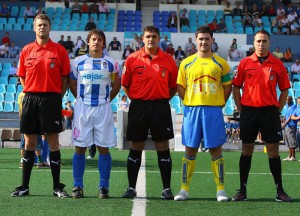 El trío arbitral con los capitanes del partido