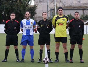 El trío arbitral con los capitanes del partido