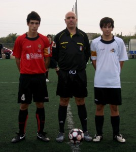 El colegiado con los capitanes del partido