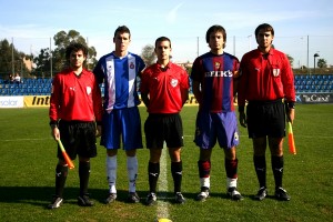 El trío arbitral con los capitnaes del partido