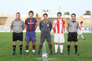 El trío arbitral con los capitanes del partido