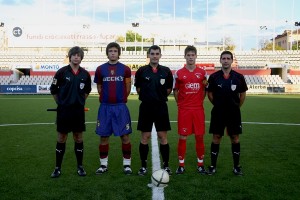 El trío arbitral con los capitanes del partido