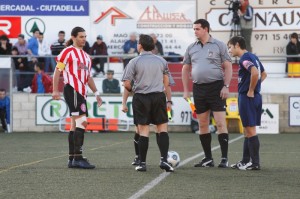 El trío arbitral con los capitanes del partido