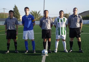 El trío arbitral con los capitanes del partido