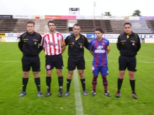 El trio arbitral con los capitanes del partido