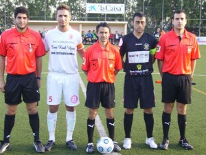 El trío arbitral con los capitanes del partido