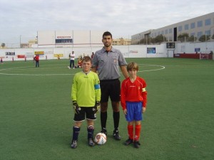 El colegiado con los capitanes del partido