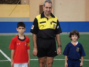 El colegiado con los capitanes del partido