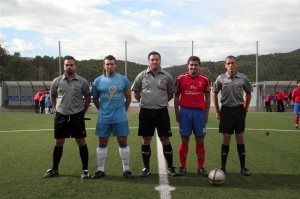 El trío arbitral con los capitanes del partido