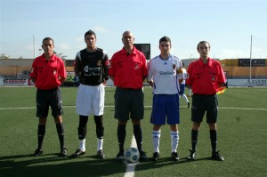 El trío arbitral con los capitanes del partido