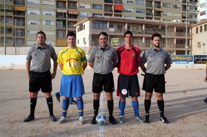 El trío arbitral con los capitanes del partido