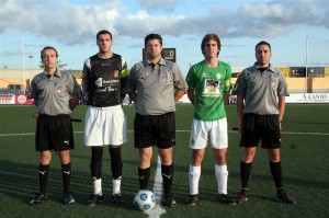 El trío arbitral con los capitanes del partido