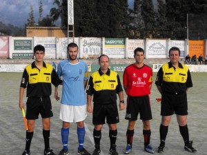 El trío arbitral con los capitanes del partido