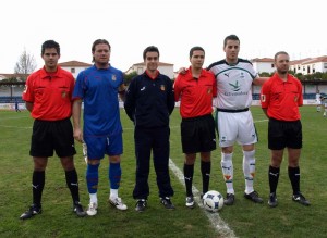 El trío arbitral con los capitanes del partido