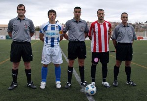 El trío arbitral con los capitanes del partido