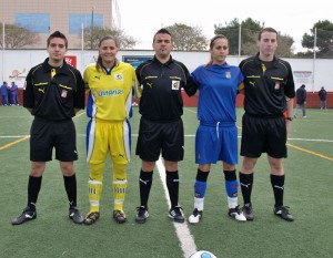 El trio arbitral con las capitanas del partido