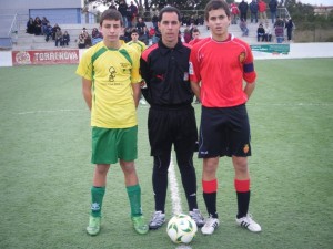 El colegiado con los capitanes del partido