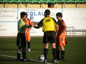 El colegiado con los capitanes del partido