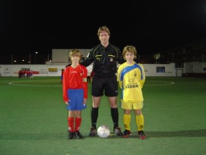 El colegiado con los capitanes del partido