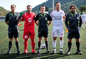 El trio arbitral con los capitanes del partido