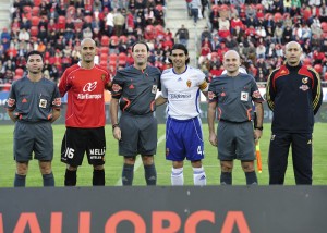 El trío arbitral con los capitanes del partido