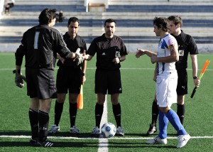 El trio arbitral con los capitanes del partido