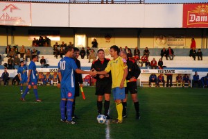 El trio arbitral con los capitanes del partido