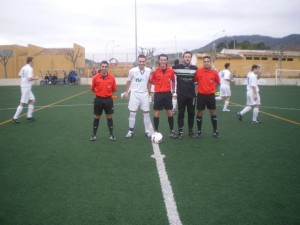 El trío arbitral con los capitanes del partido