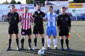 El trío arbitral con los capitanes del partido