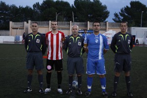 El trío arbitral con los capitanes del partido