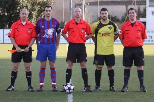 El trío arbitral con los capitanes del partido