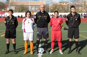 El trio arbitral con las capitanas del partido