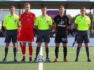 El trio arbitral con los capitanes del partido