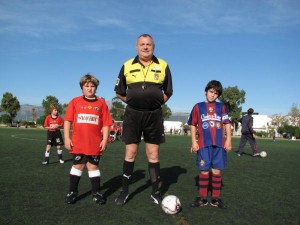 El colegiado con los capitanes del partido