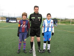 El colegiado con los capitanes del partido