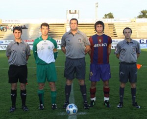 El trío arbitral con los capitanes del partido