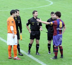 El trío arbitral con los capitanes del partido